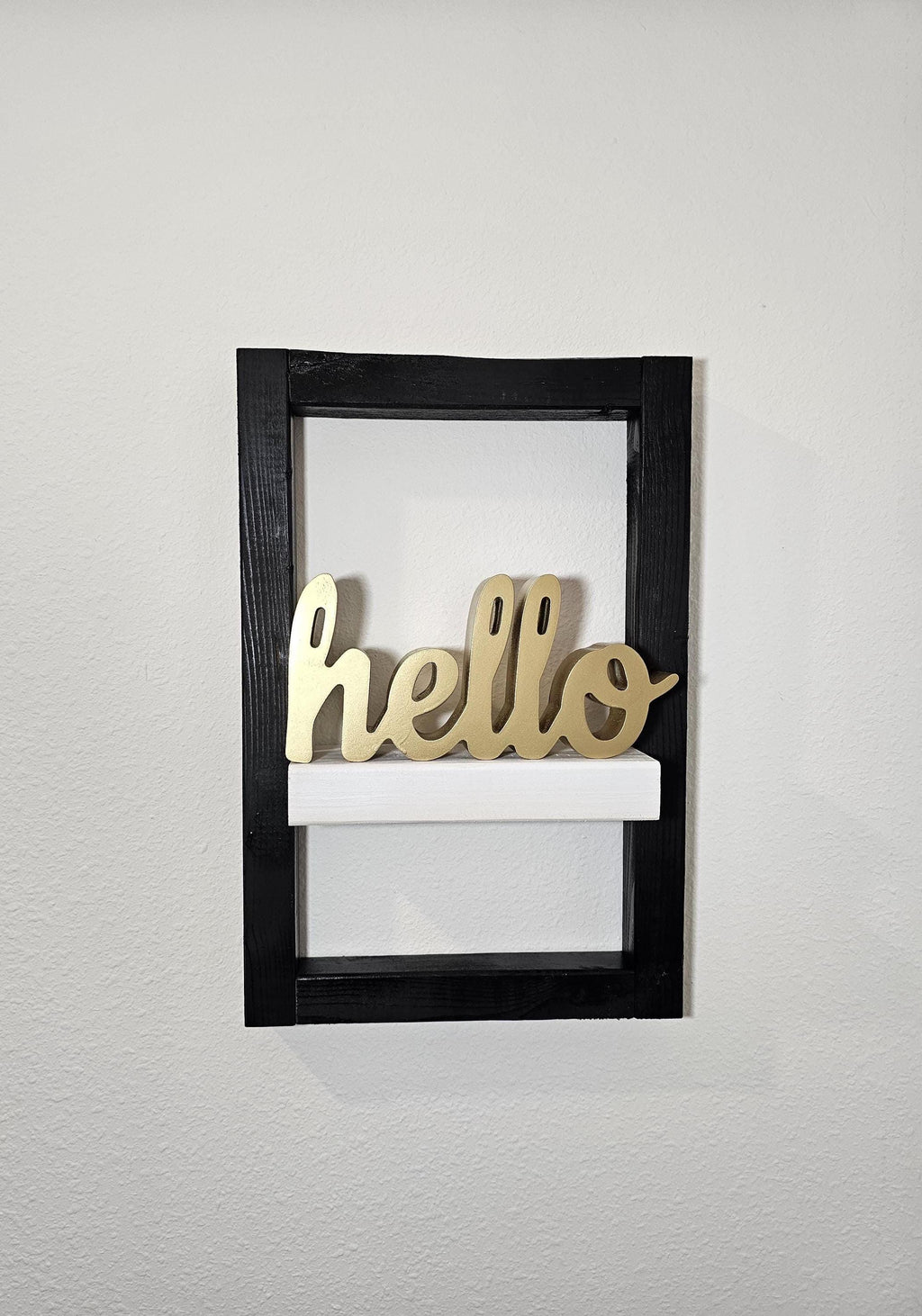 Framed wall shelf styled with a gold hello sign