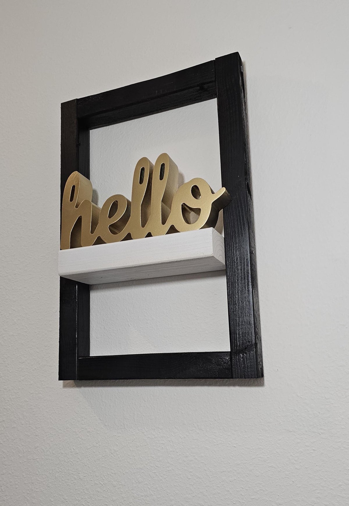White display ledge within the painted black wood frame