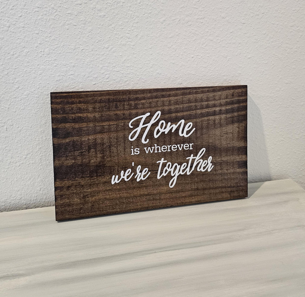 Wooden quote sign reading Home is wherever we're together